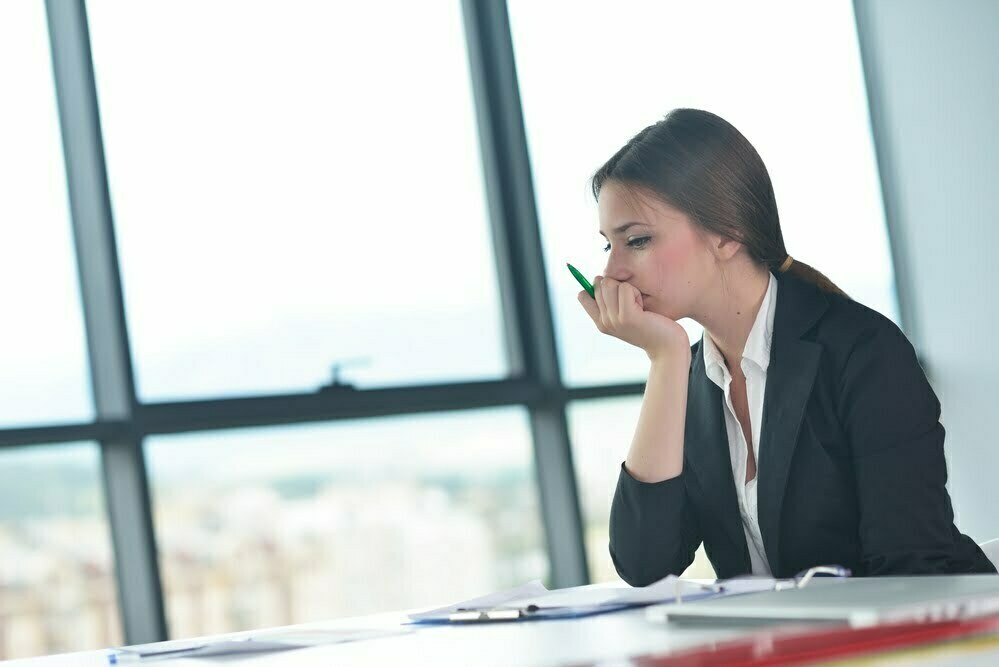 Depressed business woman sitting at a desk at an office